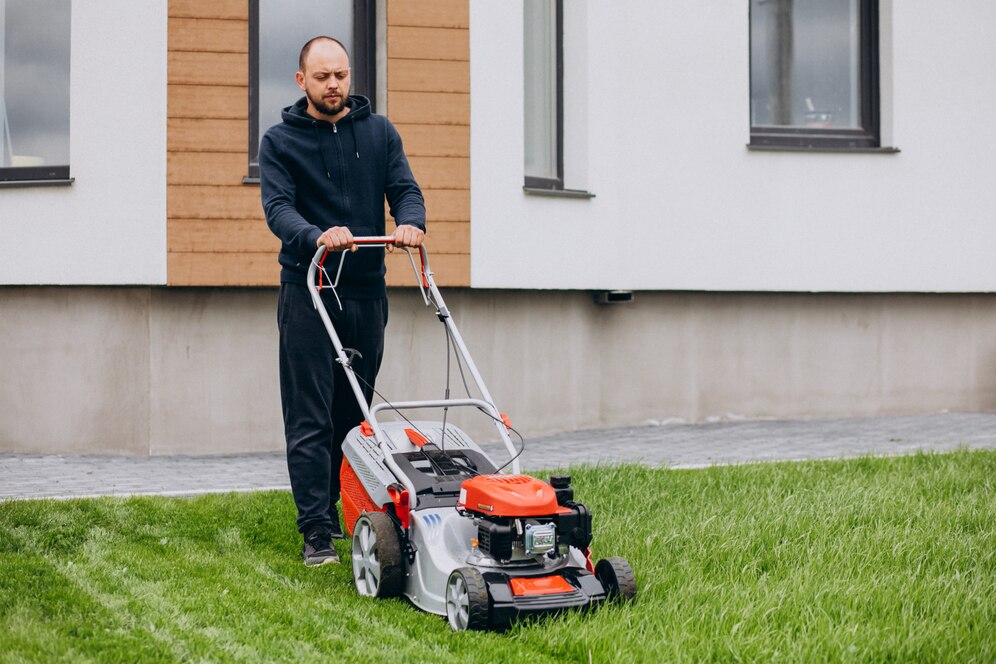 man-cutting-grass-with-lawn-mover-back-yard_1303-22793